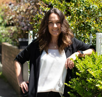 Marisa De Salvo, founder of The Five, standing outdoors and smiling